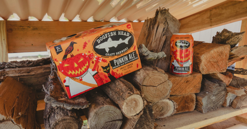 Dogfish Head Releasing 2024 Art Series Punkin Ale 10 Dogfish Head Punkin Ale 12 oz. can and 6-pack on top of a pile of wood