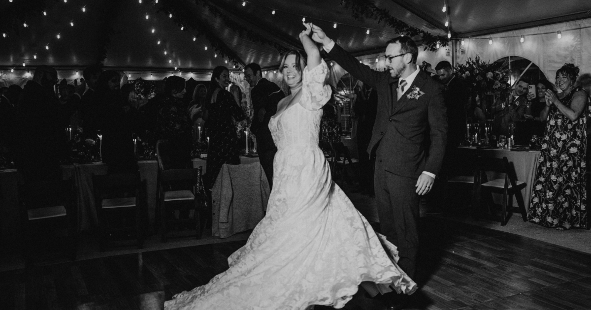 Dogfish Head Weddings - Love is INN the Air 38 a groom twirling a bride in a black and white photo
