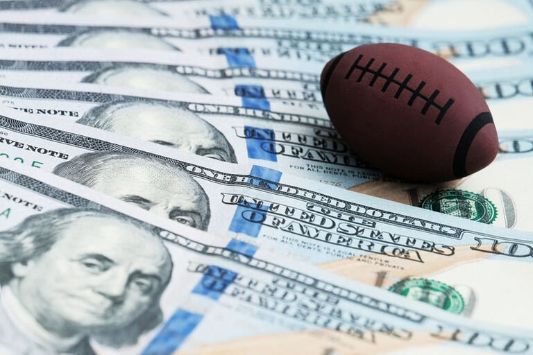 Stacks of dollar bills arranged on a shelf, symbolizing the odds, payouts, and value comparisons discussed in sports betting and NFL sportsbook analysis.