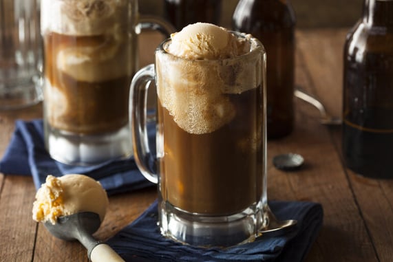 Creamy root beer float in a frosty glass mug, topped with vanilla ice cream, celebrating a classic American beer-inspired refreshment.