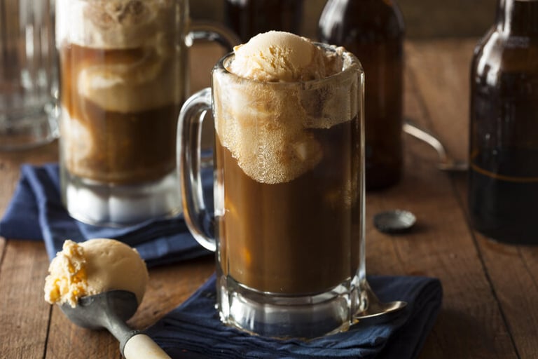 Creamy root beer float in a frosty glass mug, topped with vanilla ice cream, celebrating a classic American beer-inspired refreshment.