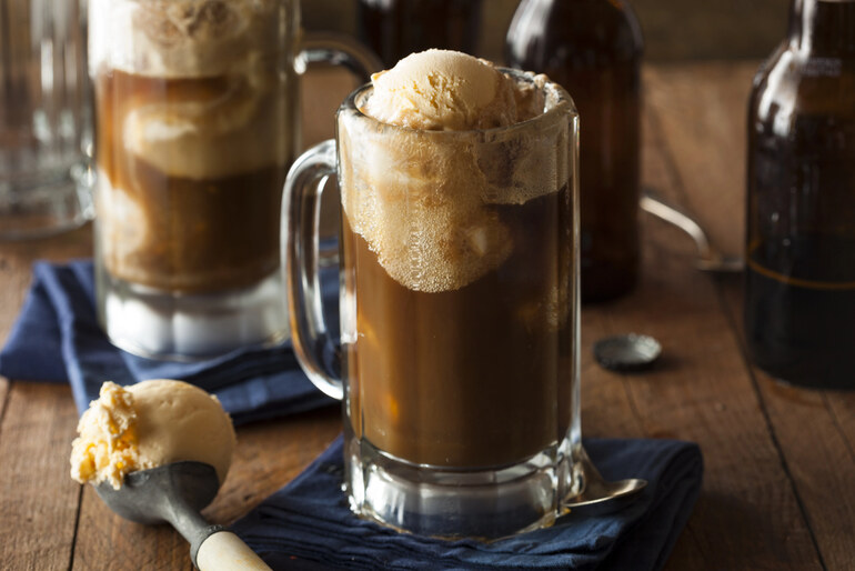 Creamy root beer float in a frosty glass mug, topped with vanilla ice cream, celebrating a classic American beer-inspired refreshment.