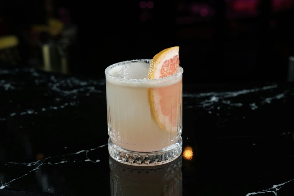 A Bodega Dog beer cocktail made with gin and grapefruit, with a fresh grapefruit garnish.