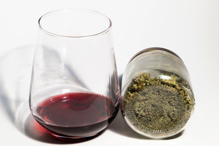 THC-infused non-alcoholic wine with a glass of red wine and fresh grapes, showcasing the emerging craft beverage trend.