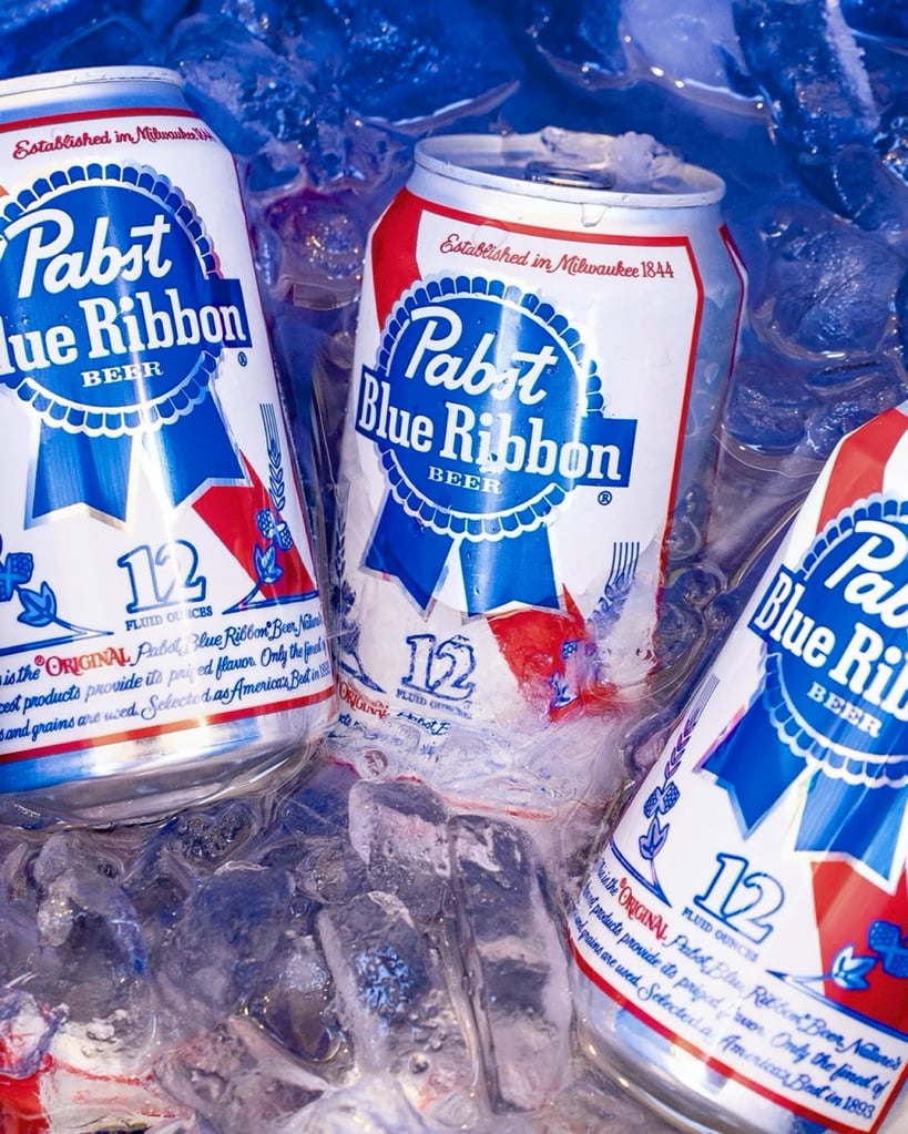 What Are Domestic Beers? Popular American Brands Explained 15 3 cans of Pabst Blue Ribbon in a cooler of ice