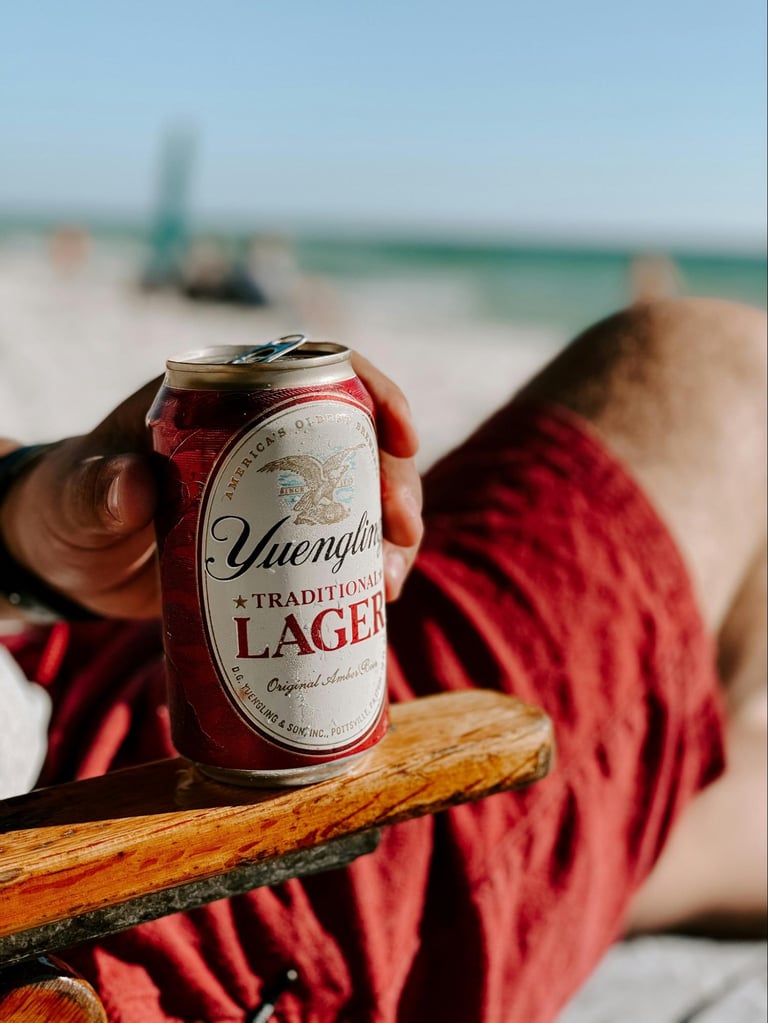 What Are Domestic Beers? Popular American Brands Explained 16 Man sitting in a beach chair hold a can of Yuengling Traditional Lager