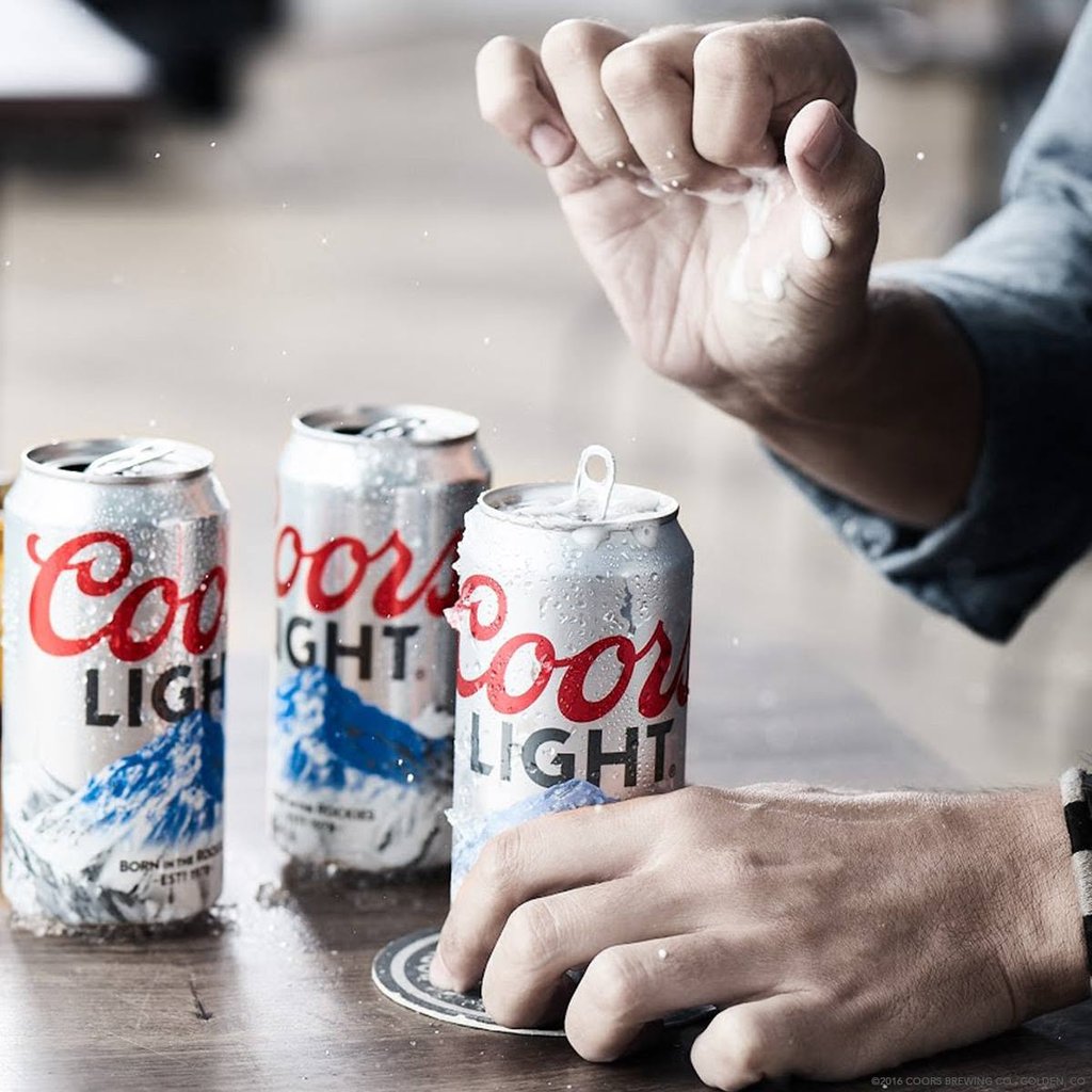What Are Domestic Beers? Popular American Brands Explained 20 A man popping the top of a can of Coors Light